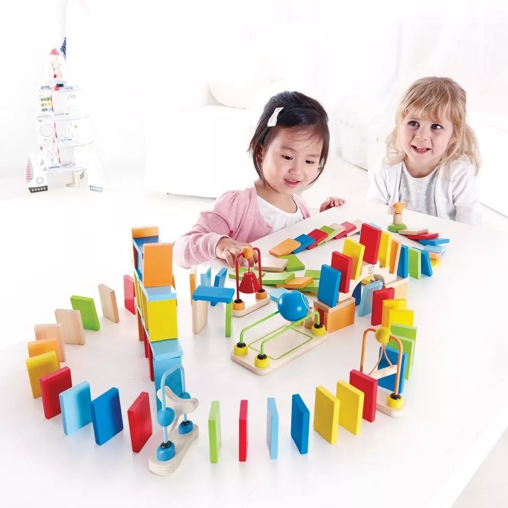 two children playing with the multicolor domino set