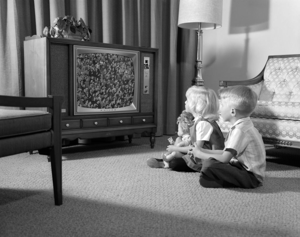 Kids sitting on the floor in front of the TV