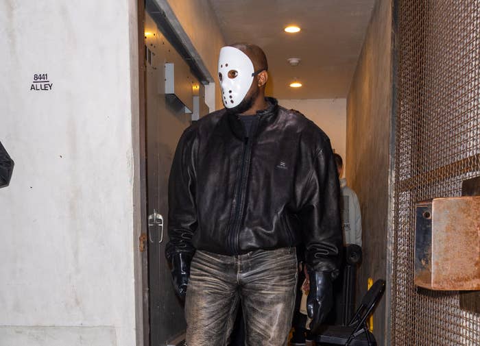 Kanye walking with a slasher mask on his face