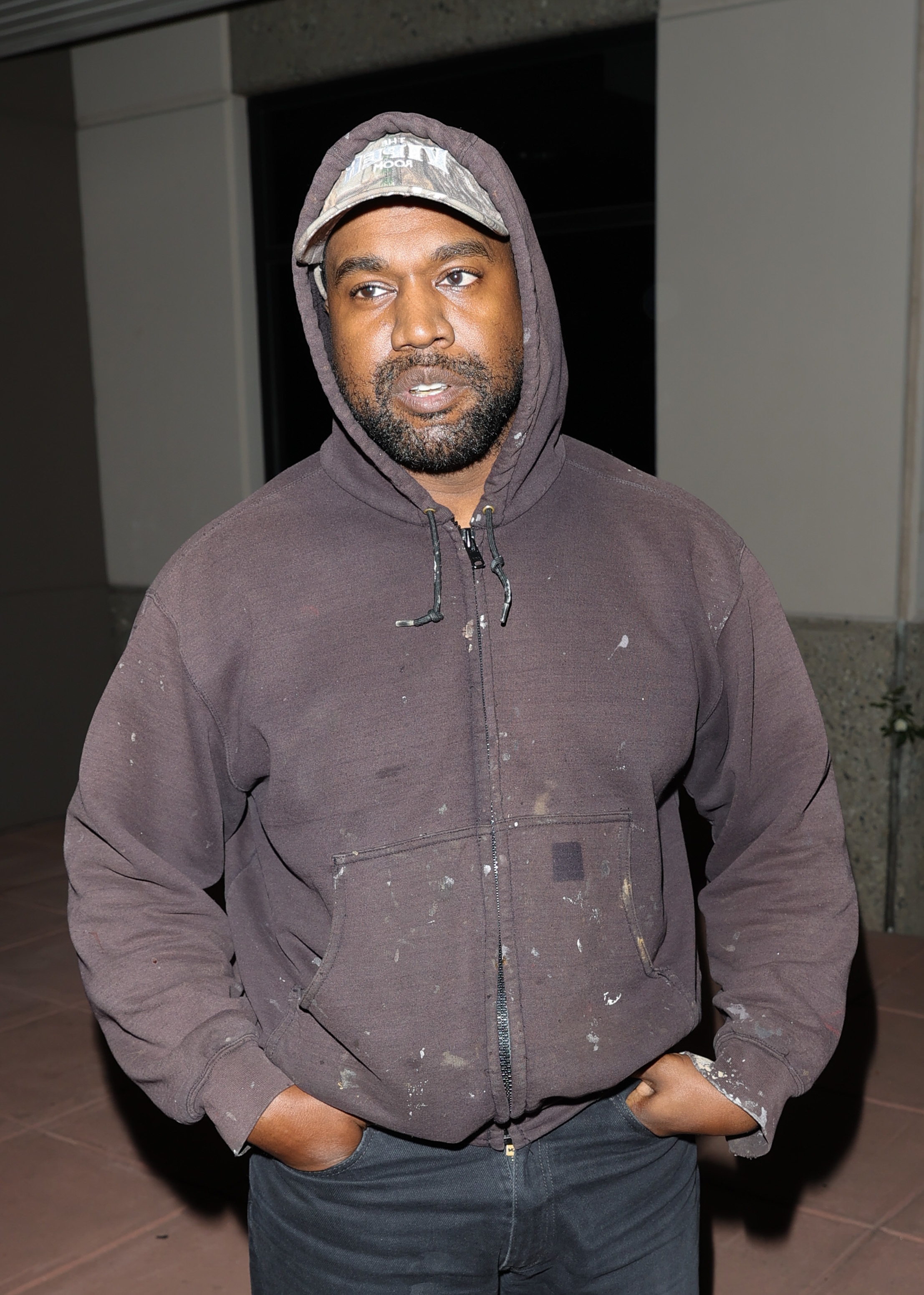 A closeup of Kanye in a dirty hoodie