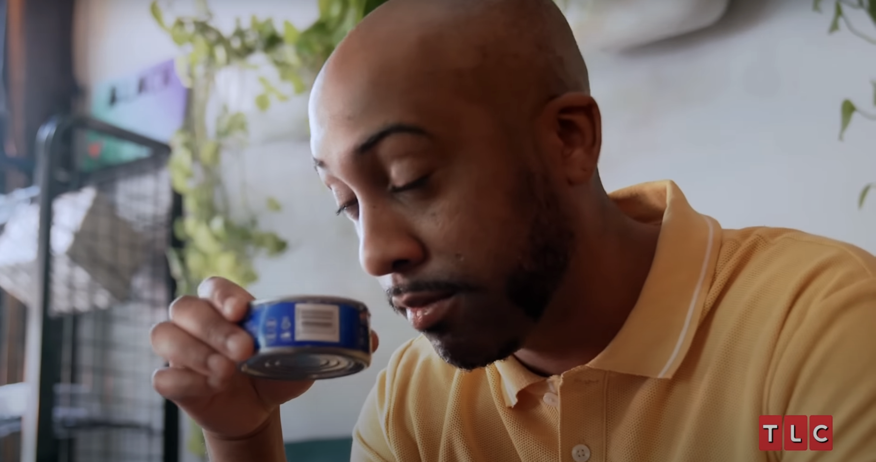 guy smelling a can of tuna