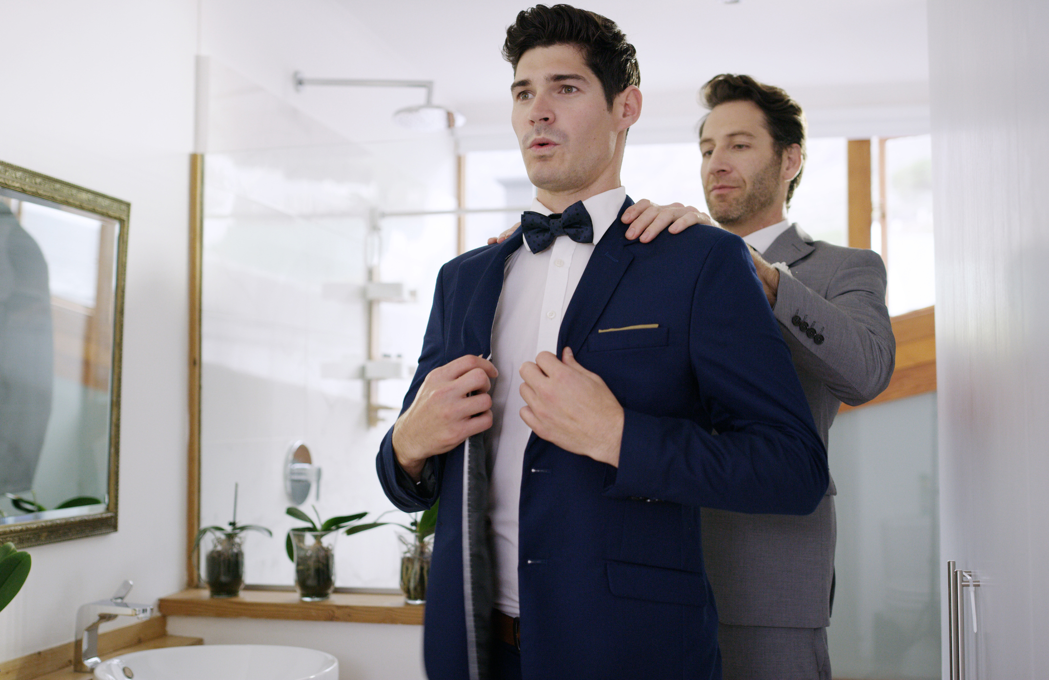 a groom and his best man fixing his suit