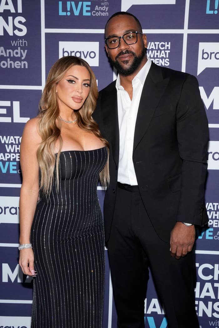 Larsa, in striped dress, and Marcus, in a suit, pose together at an event