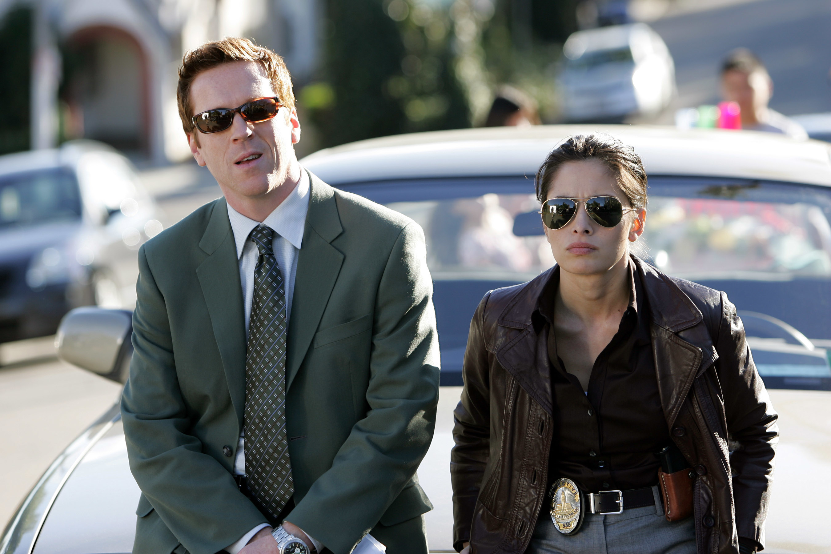 two detectives standing by their car
