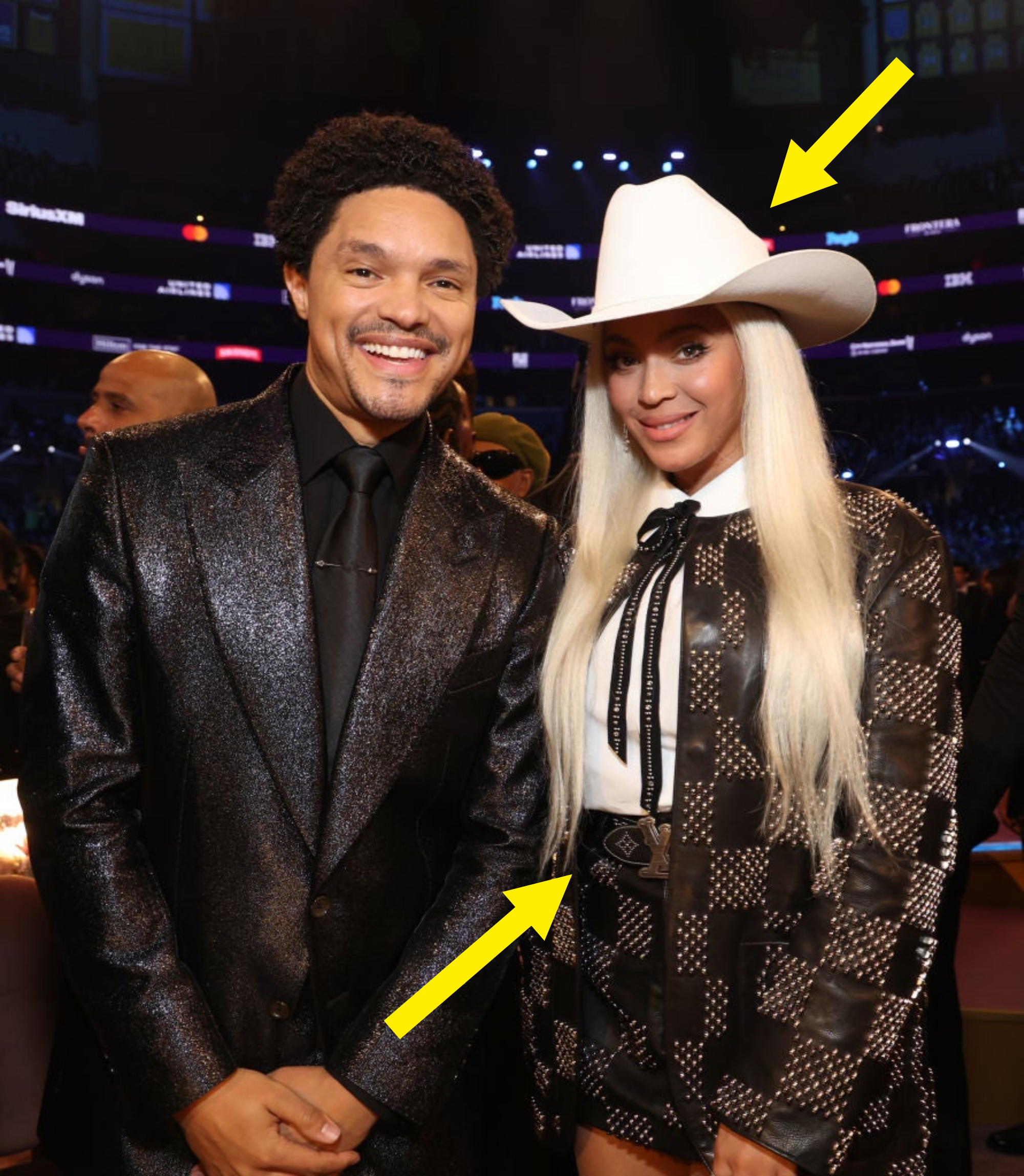 Trevor Noah in a glittering suit and Beyoncé in a studded outfit with a cowboy hat smile for a photo
