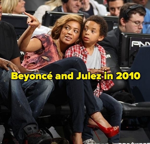 Beyoncé wearing printed top and Julez in a checkered shirt at a sports event, both seated, with Beyoncé gesturing