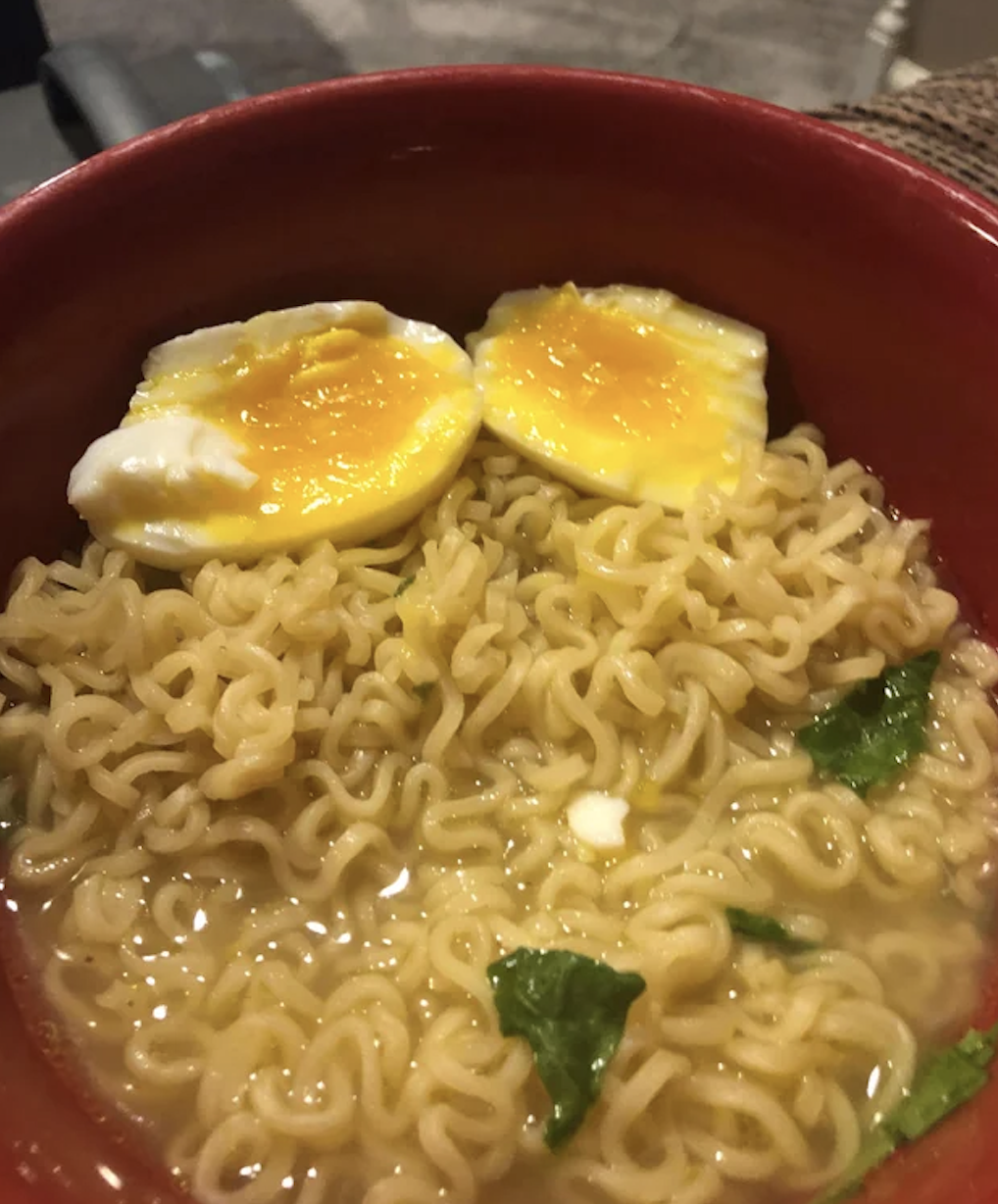 A bowl of ramen soup with an egg