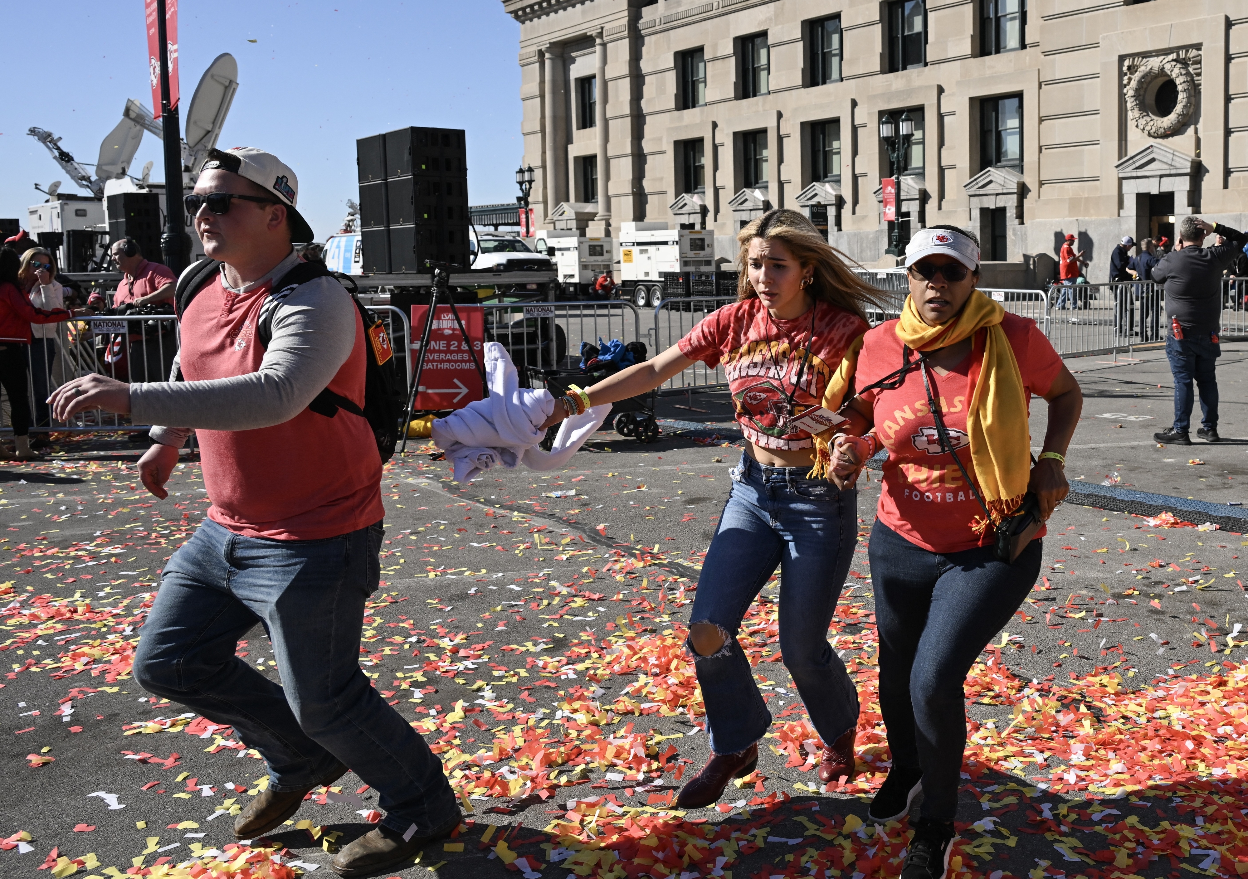 Three people fleeing gunfire at a Kansas City Chiefs Super Bowl Victory parade.