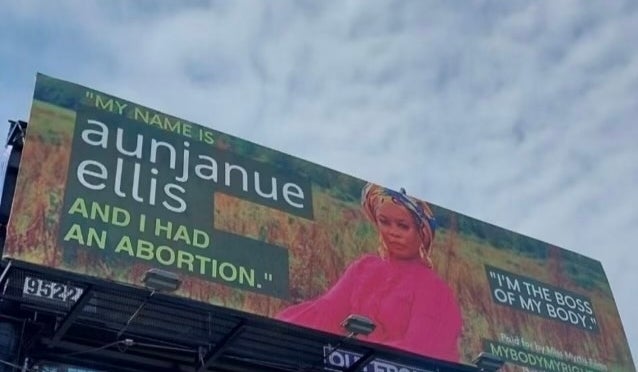 Billboard with a message on the right to choose, featuring Aunjanue in a suit