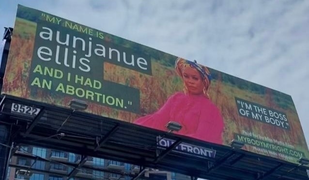 Billboard with a message on the right to choose, featuring Aunjanue in a suit