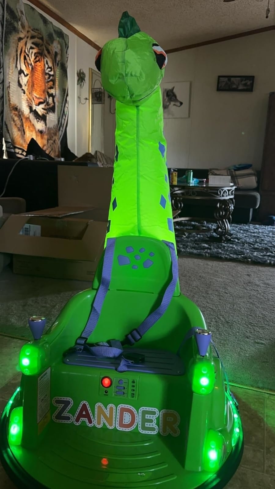 Inflatable dinosaur toy car labeled  with lights, indoors