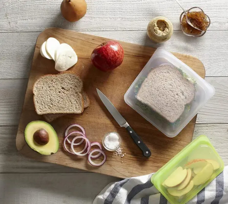 various ingredients to make a sandwich on a cutting board and sandwich in a reusable zip loc