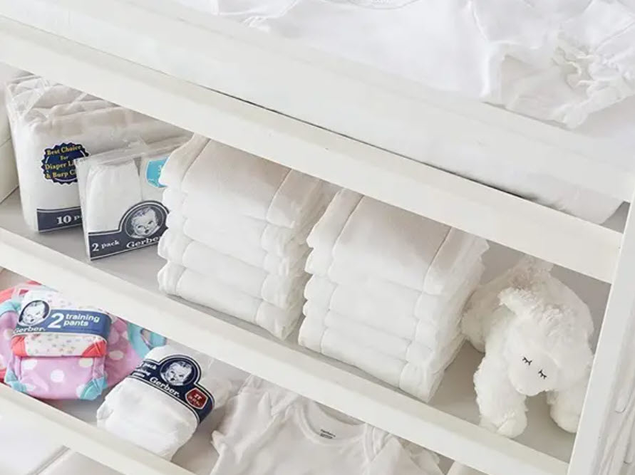 Gerber three-ply stack of diapers on shelf under crib