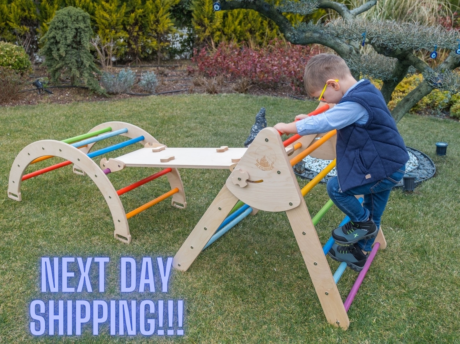 Child playing with two wooden activity ladders with a climbing platform secured between them