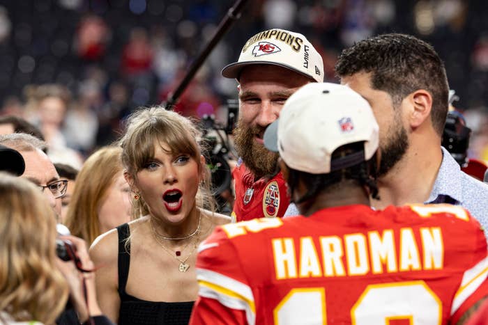 Taylor Swift standing next to Travis Kelce and looking surprised as she looks at Mecole Hardman Jr. of the KC Chiefs