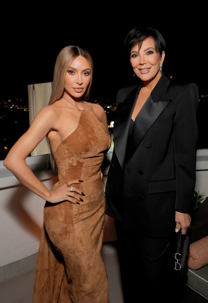 Kim and Kris pose on a balcony, Kim in a sleeveless dress, Kris in a suit jacket