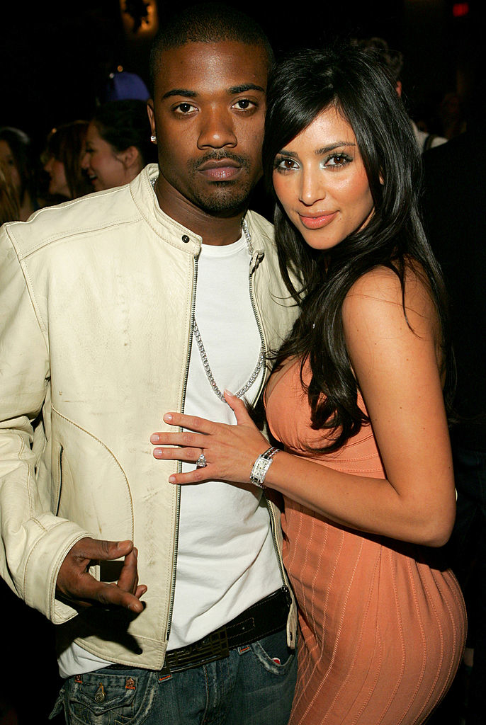 Kim and Ray J posing with their arms around each other
