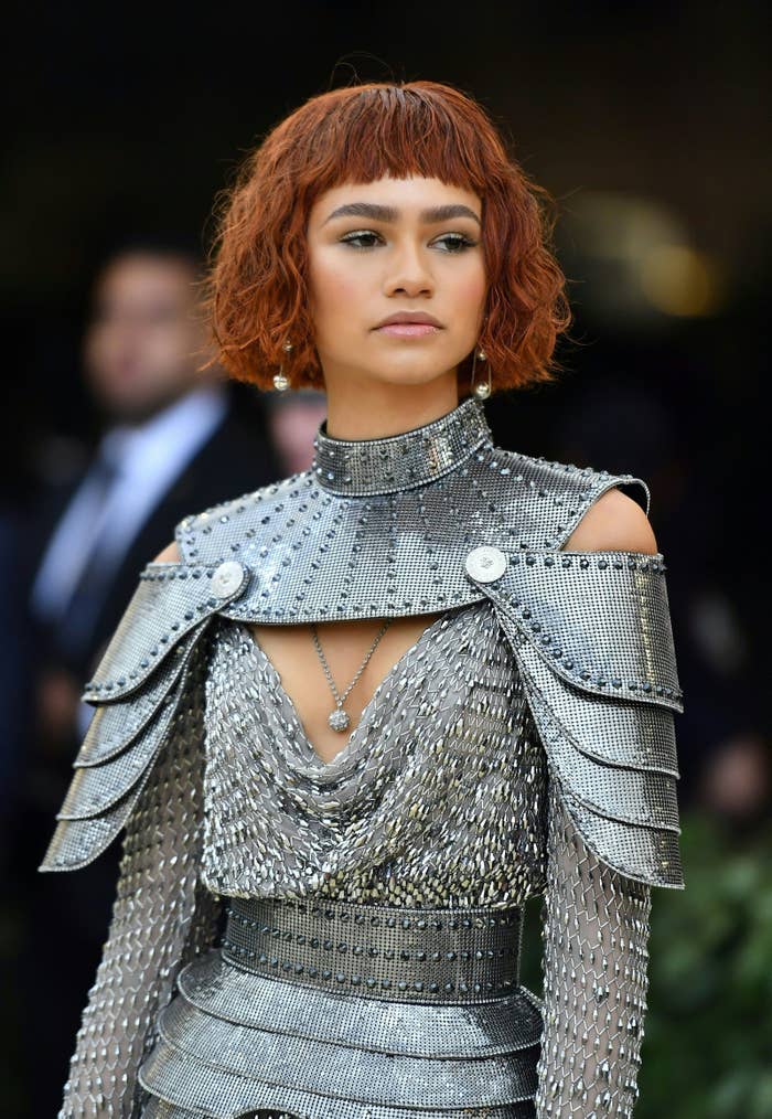 Zendaya in a metallic, structured shoulder outfit with a layered necklace