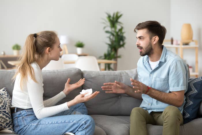 Two people having a conversation while sitting on a couch