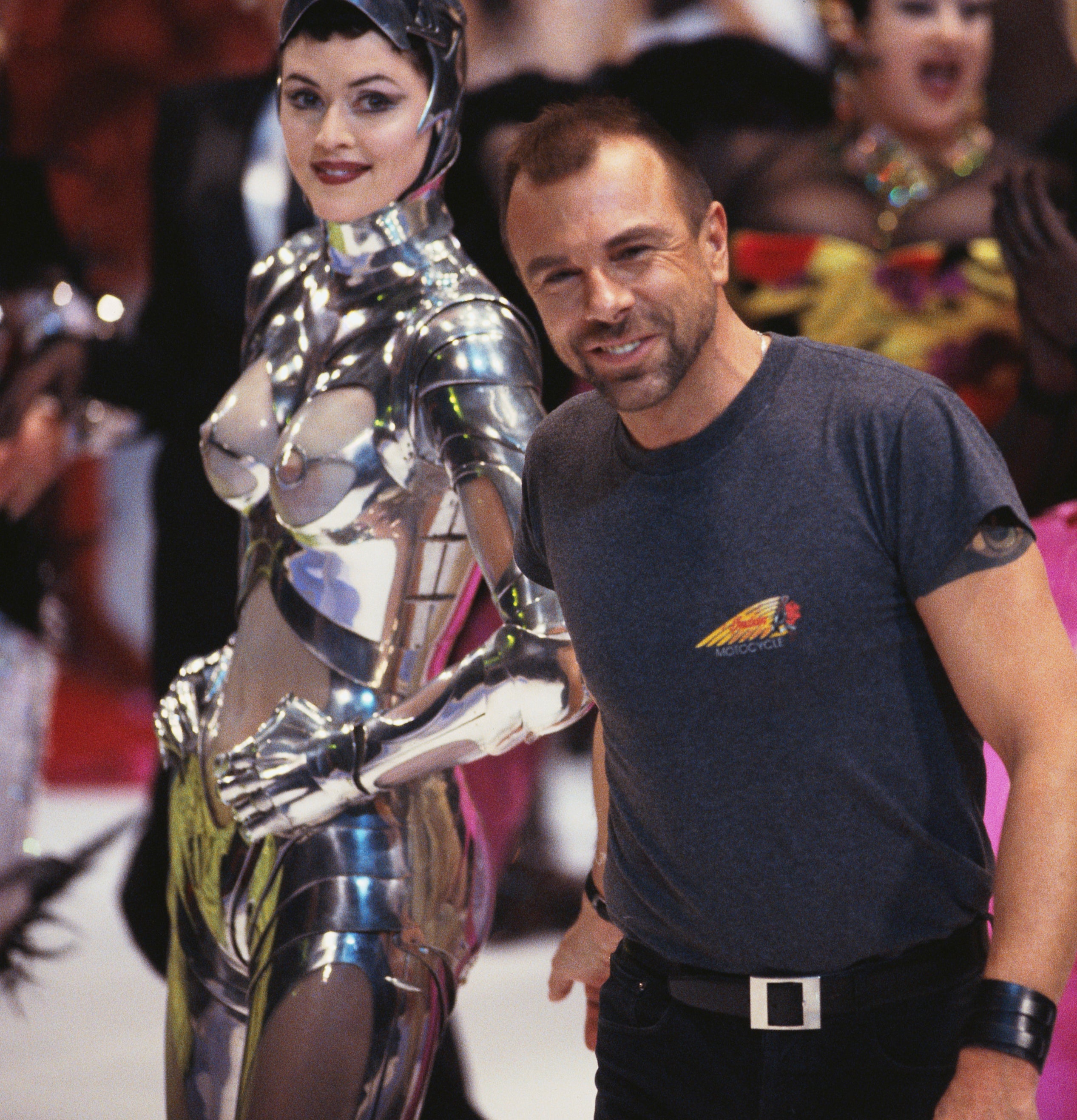 Manfred Thierry Mugler with models in avant-garde outfits, one in metallic attire, on runway