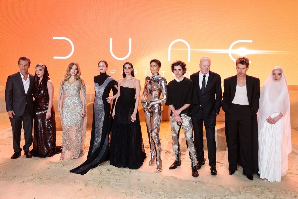 Cast of “Dune” posing together in formal attire at a premiere event