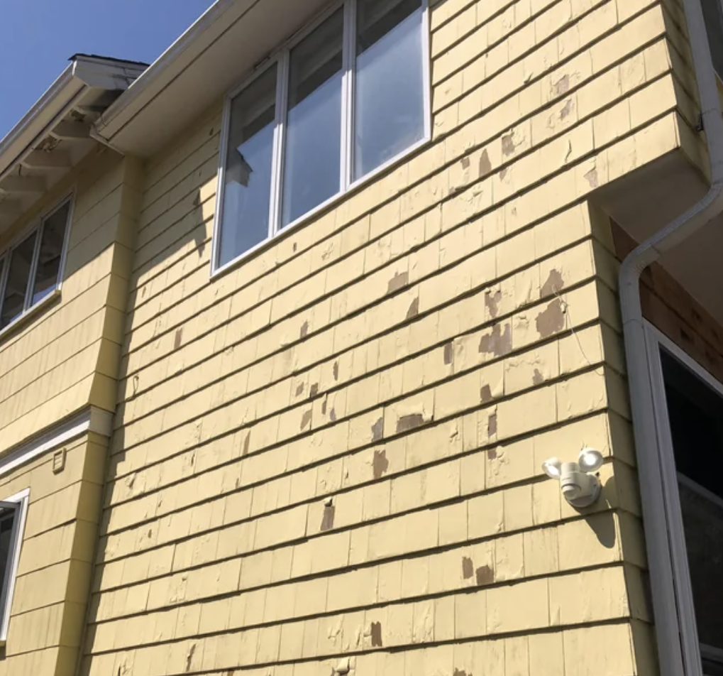 A house with peeling yellow paint