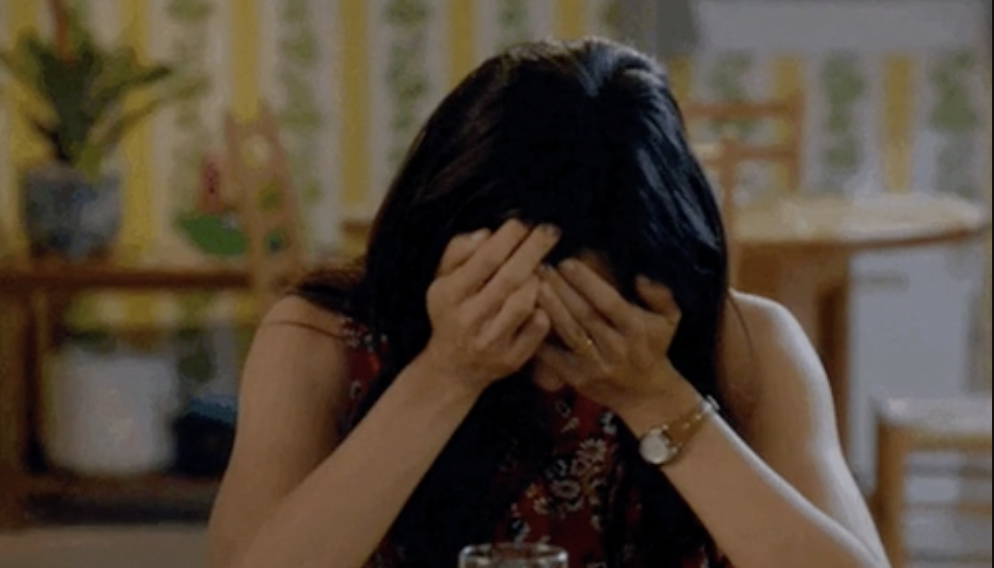 Woman with hands covering her face, emotional moment