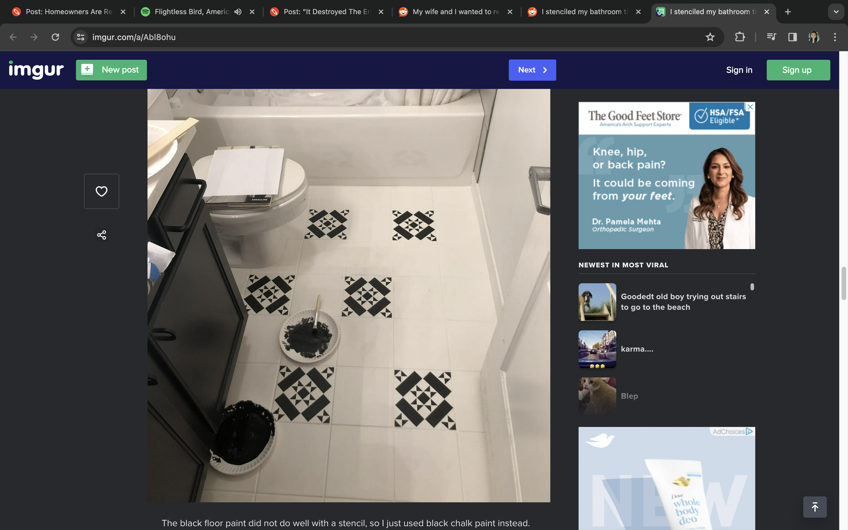 A bathroom floor with someone doing a paint touch-up next to a toilet and waste bin