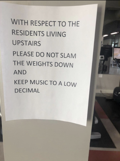 Gym sign asks to respect upstairs residents by not slamming weights and keeping music &quot;to a low decimal&quot;
