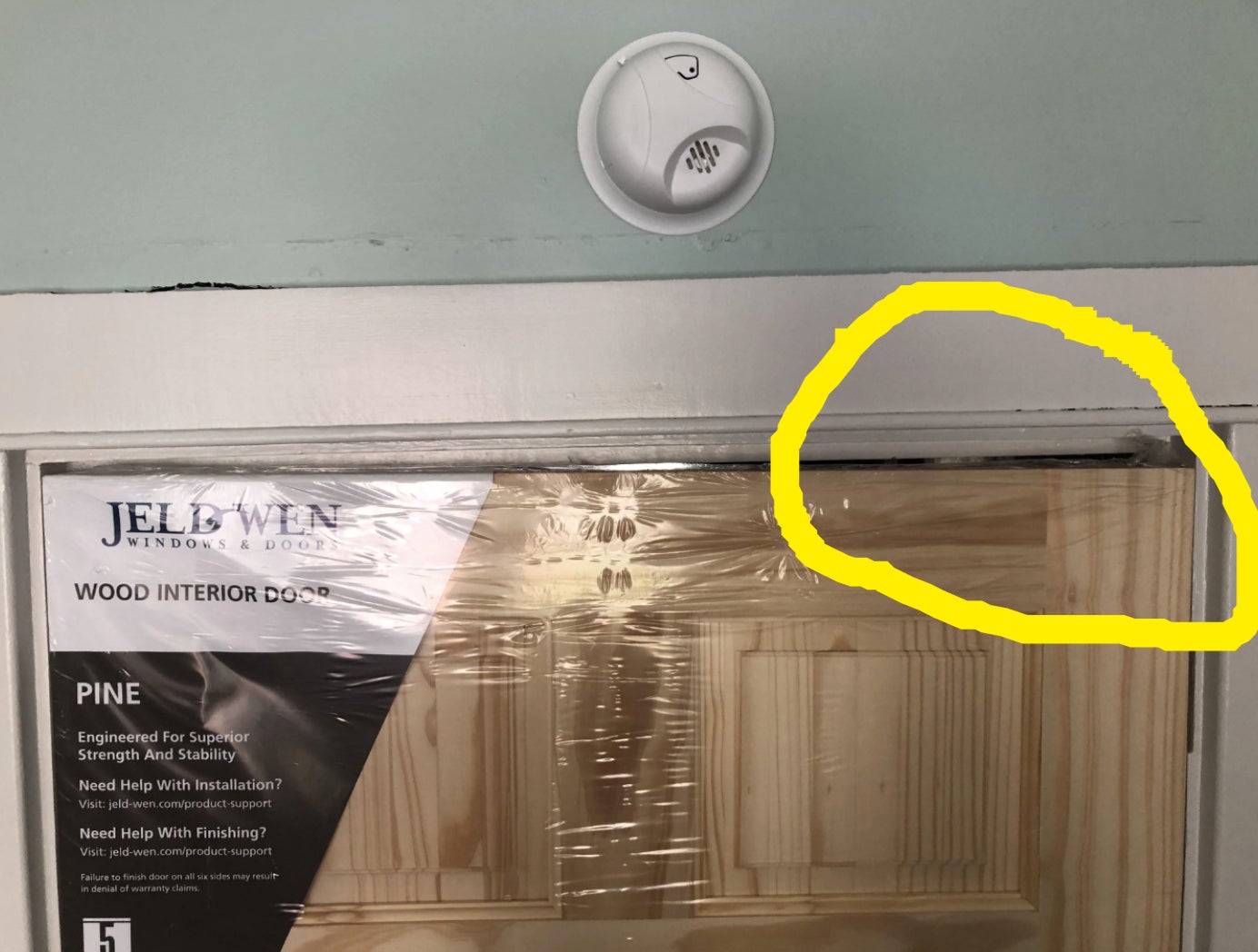 A new wooden door with protective plastic covering that doesn&#x27;t fit
