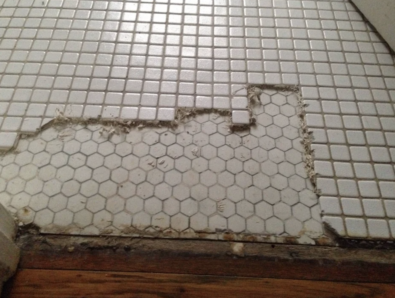 Vintage white hexagonal bathroom tile, freestanding tub with shower, period-appropriate fixtures
