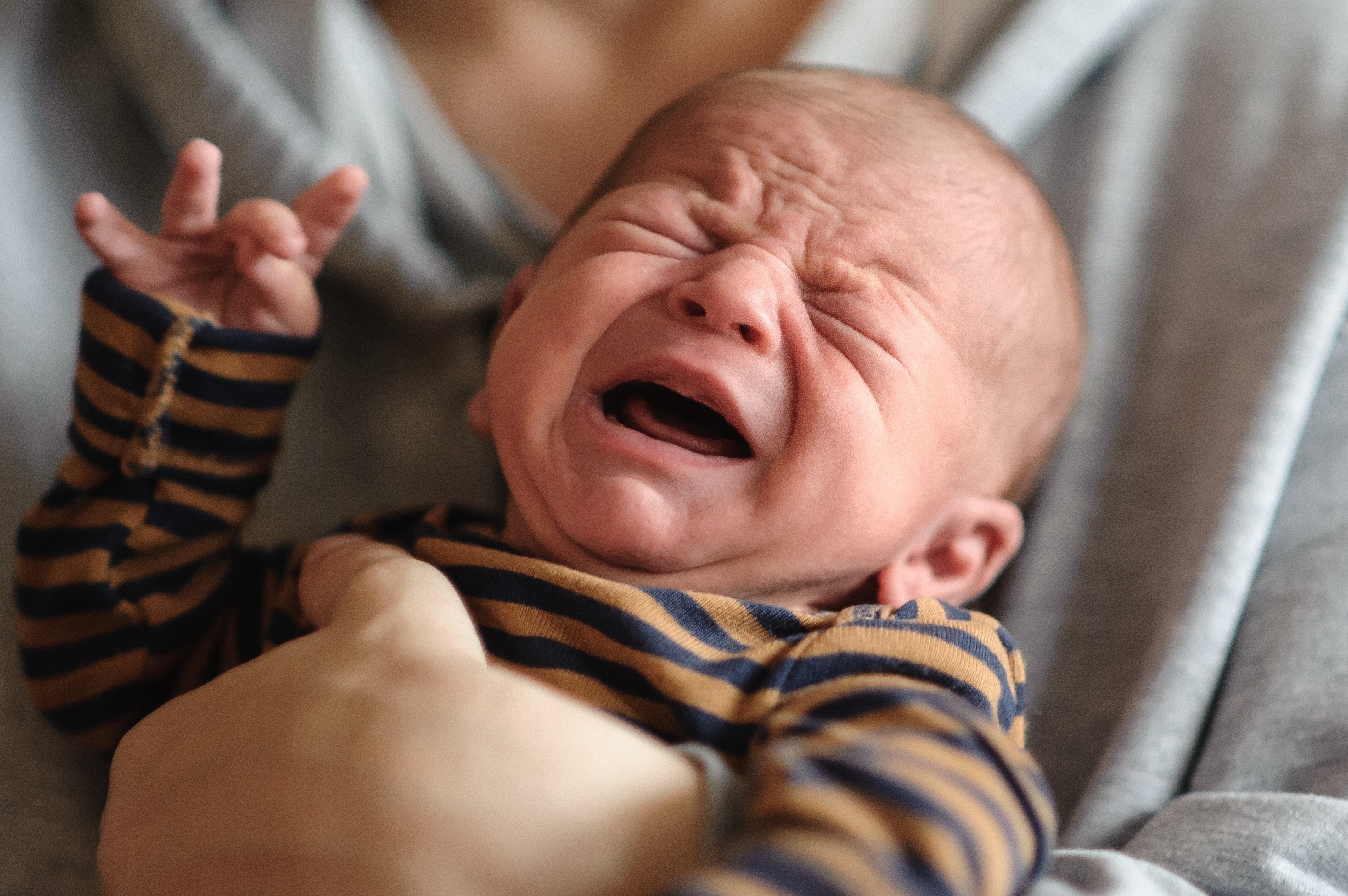 Crying infant being held