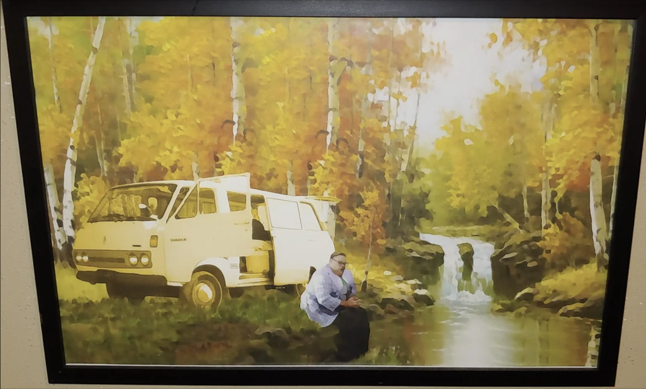 A painting of a person next to a van in a forest scene with a waterfall, displayed on a wall