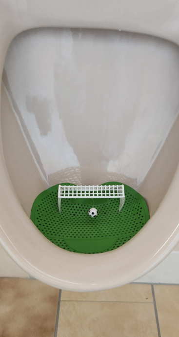 Urinal with a soccer goal-themed deodorizer block