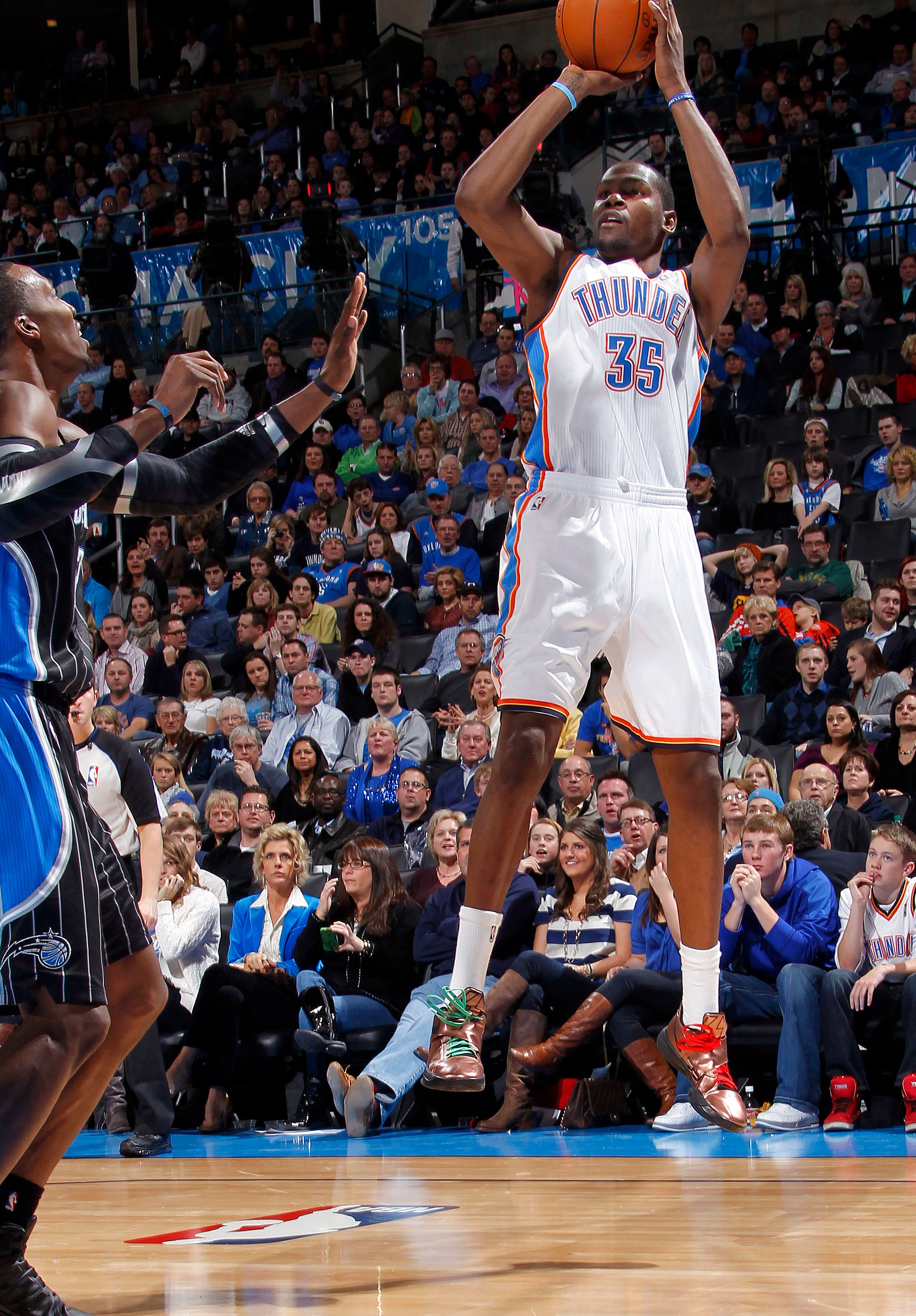 Kevin Durant #35 of the Oklahoma City Thunder shoots over Dwight Howard #12 of the Orlando Magic during an NBA game on December 25, 2011 at the Chesapeake Energy Arena in Oklahoma City, Oklahoma.
