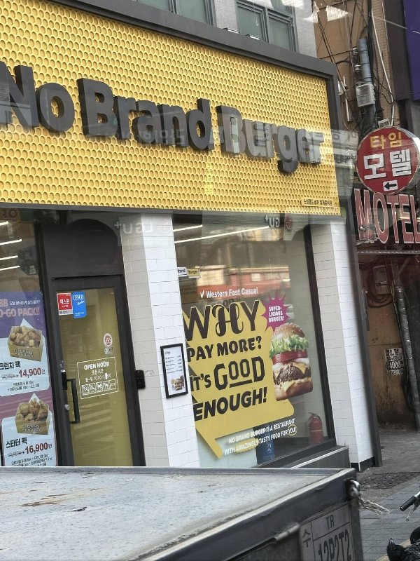 Storefront of 'No Brand Burger' with an  for Western fast food, visible in an urban setting. No persons in image