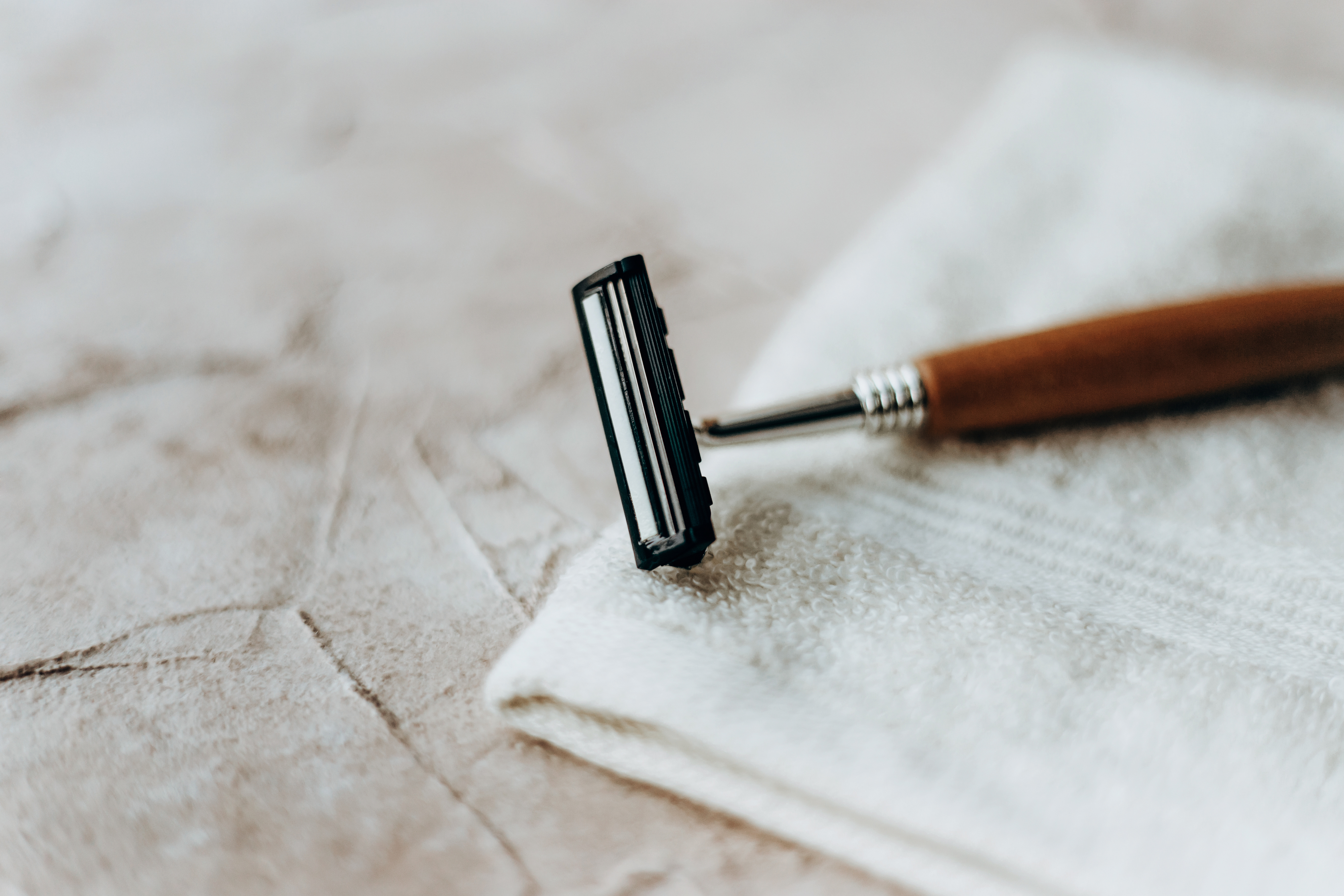Razor with a wooden handle on a textured surface