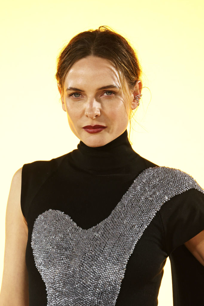 Rebecca in a black turtleneck with a shimmering silver design, gazing forward