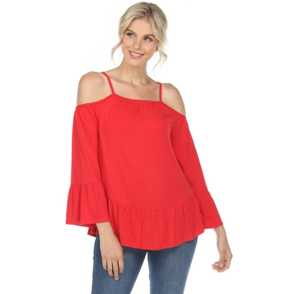 Person in a red off-shoulder top with ruffle details and jeans standing against a plain background