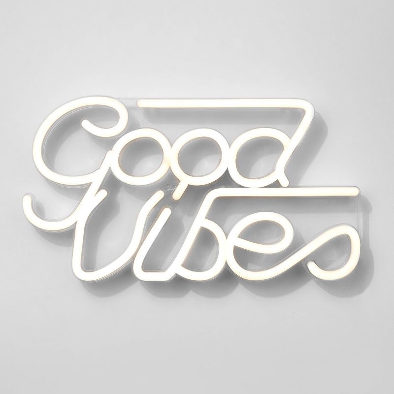 Neon sign on a wall reading &#x27;Good Vibes&#x27; in cursive script, used for home decor inspiration
