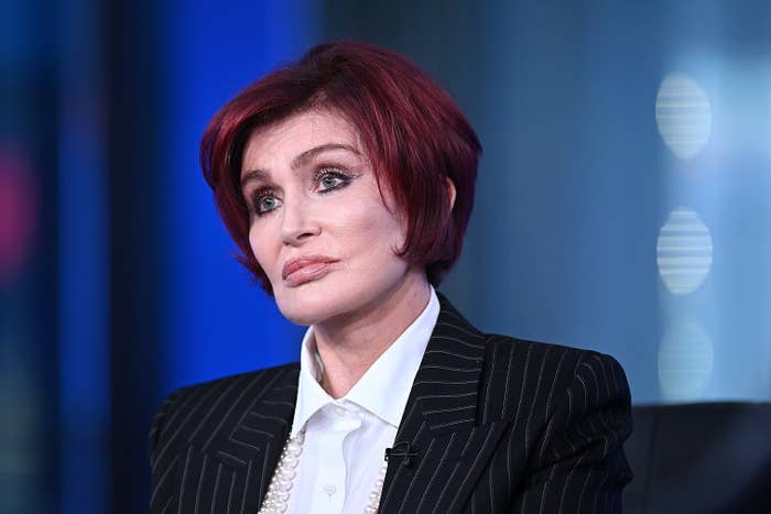 Sharon Osbourne in a striped suit with a pearl necklace