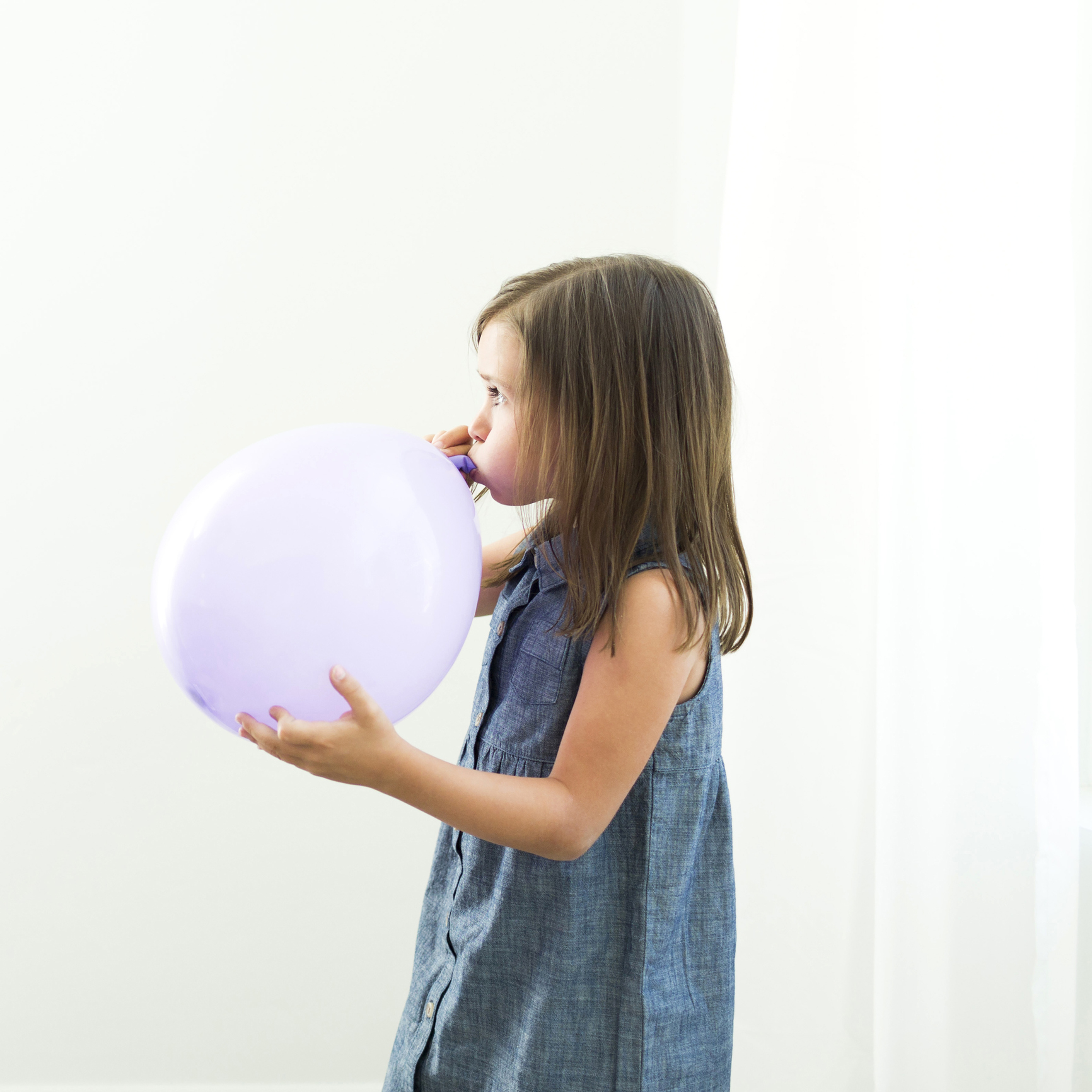 A girl blowing a balloon