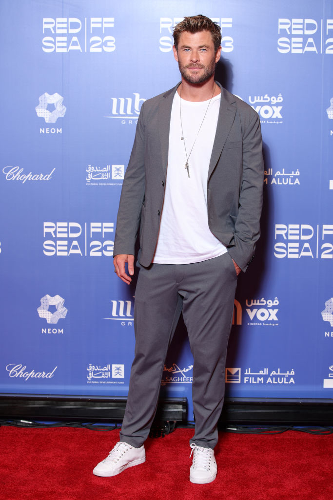 Chris Hemsworth in a gray suit with white sneakers at a red carpet event