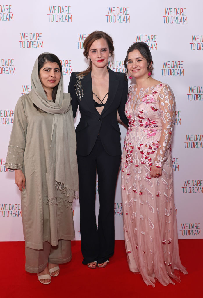 Emma in a pantsuit standing with Malala Yousafzai and another woman