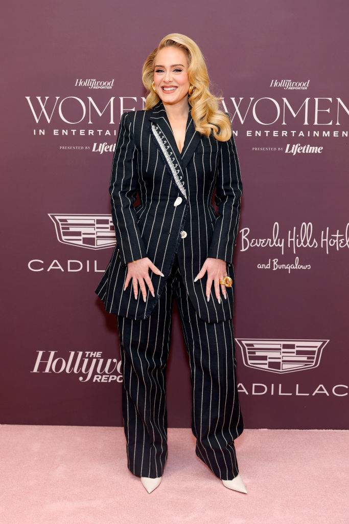 Adele smiling in a pin-striped pantsuit with embellished lapel