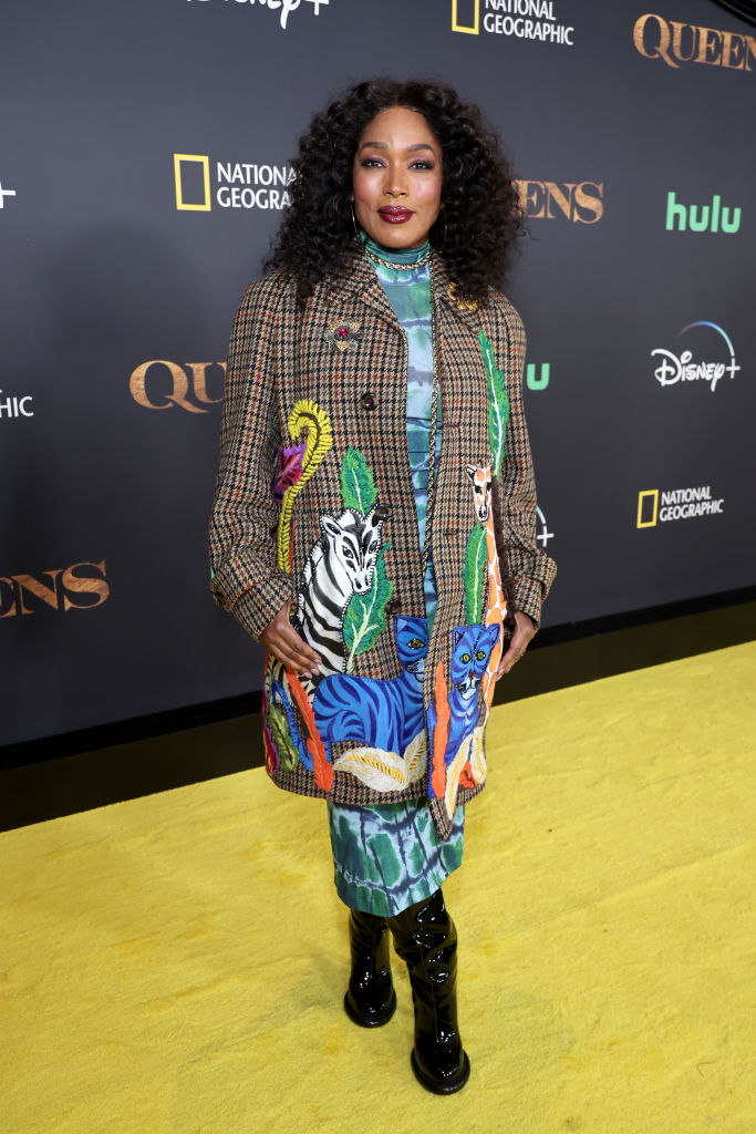 Angela Bassett on the yellow carpet, wearing an animal-print dress with a plaid blazer, at a premiere event