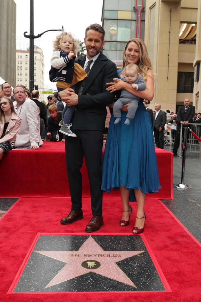 Ryan Reynolds in a suit, Blake Lively in a blue dress, with their two children, at Ryan's Hollywood Walk of Fame star ceremony