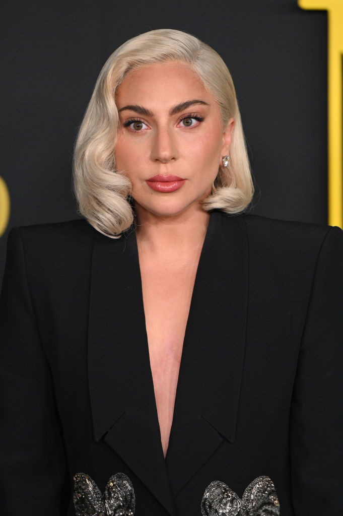 Lady Gaga wearing a black suit with embellished sleeves, posing for the camera