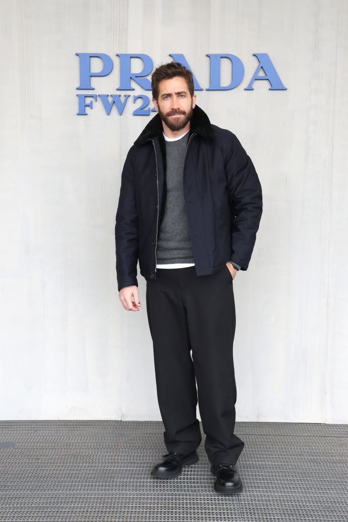 Jake in a black jacket and pants with a gray sweater at the Prada FW event