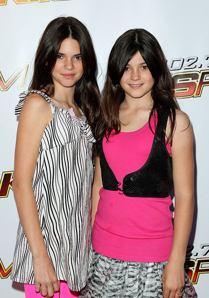 Kendall in a striped top with ruffles with her sister Kylie, in a pink tank top and black vest